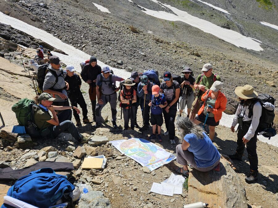 Randonnée en montagne, groupe autour d'une carte pédagogique