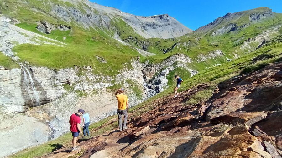 Groupe de randonneurs sur sentier près d'une cascade